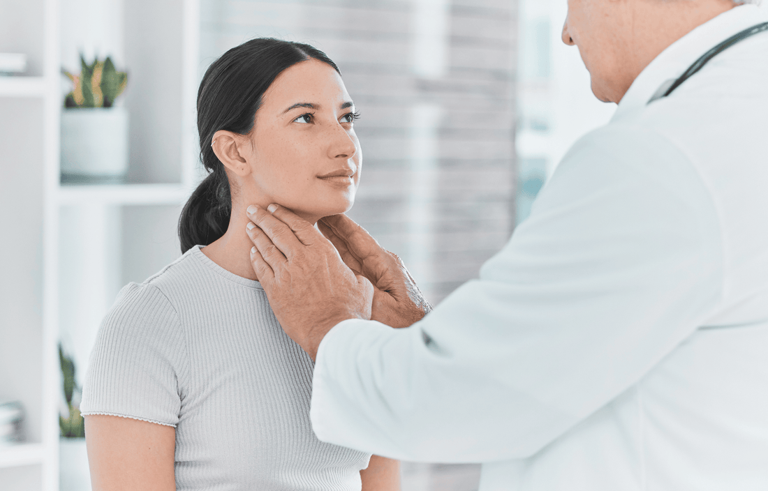 Doctor performing a thyroid neck check on a female patient concerned about metabolism